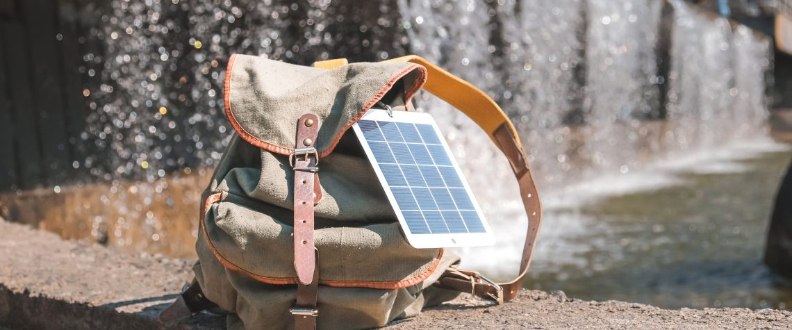 Sustainable Travel: How to Minimize Your Environmental Impact 1 Portable solar panel.Traveler uses green energy to charge gadget